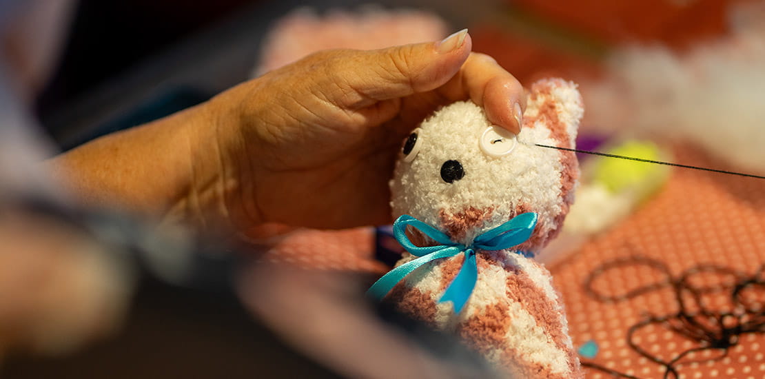 Finishing touches being added to a cuddly cat made during a workshop with the Supercrafters